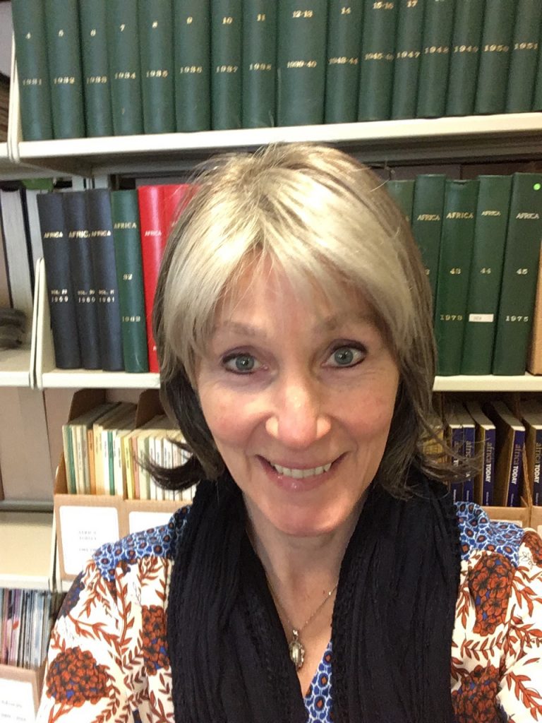 Woman with gray hair and blond streak, smiling