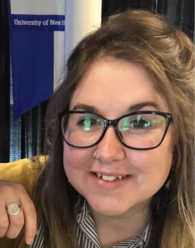 woman with brown hair and glasses, smiling