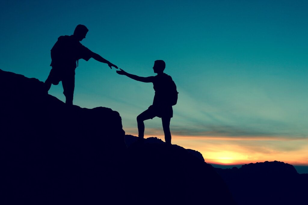 a friend lending a friend a hand while hiking