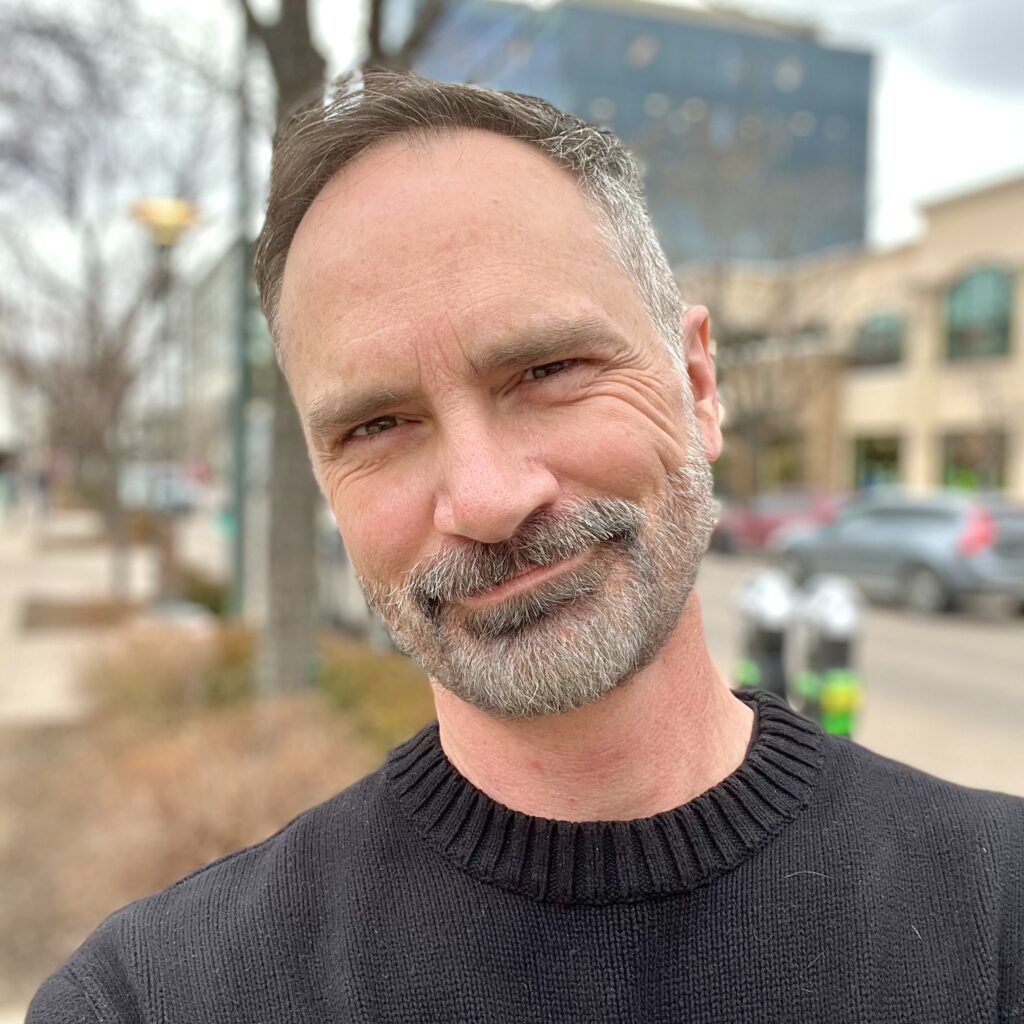 photo of a man with a beard looking directly into the camera and smiling