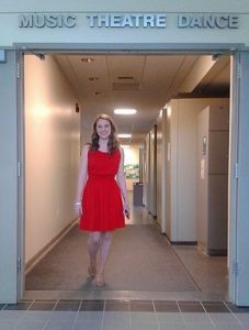 Woman posing outside in the theater hallway