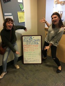 Two students posing with the IDS sign