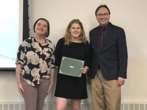 Hannah and Matt posing for a picture with a student