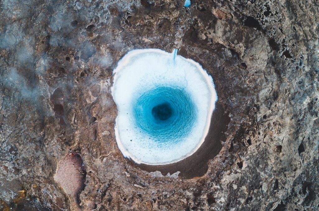 an aerial view of a blue hole in the ground