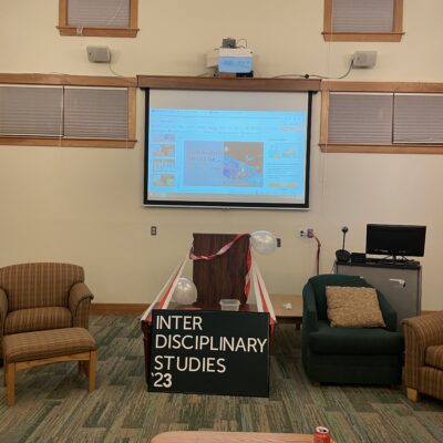 Podium and screen with IDS poster at the end of year gathering